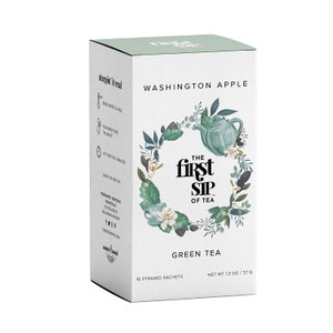 May include: A white box of "The First Sip of Tea" green tea. The box features the text "Washington Apple" and a floral design with a teapot. It contains 16 pyramid sachets and weighs 1.3 ounces (37 grams).