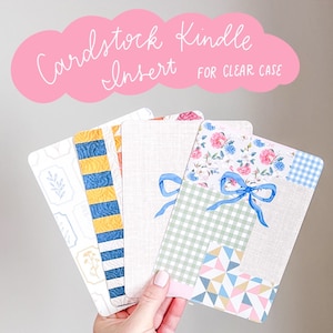 May include: Five different patterned cardstock inserts for a clear Kindle case. The inserts feature a variety of patterns, including floral, plaid, and geometric designs. The text "Cardstock Kindle Insert for Clear Case" is visible at the top of the image.