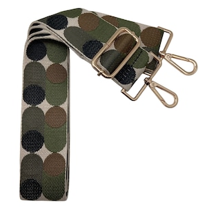 May include: A green, brown, and black polka dot patterned adjustable strap with gold metal hardware. The strap has two swivel clips.