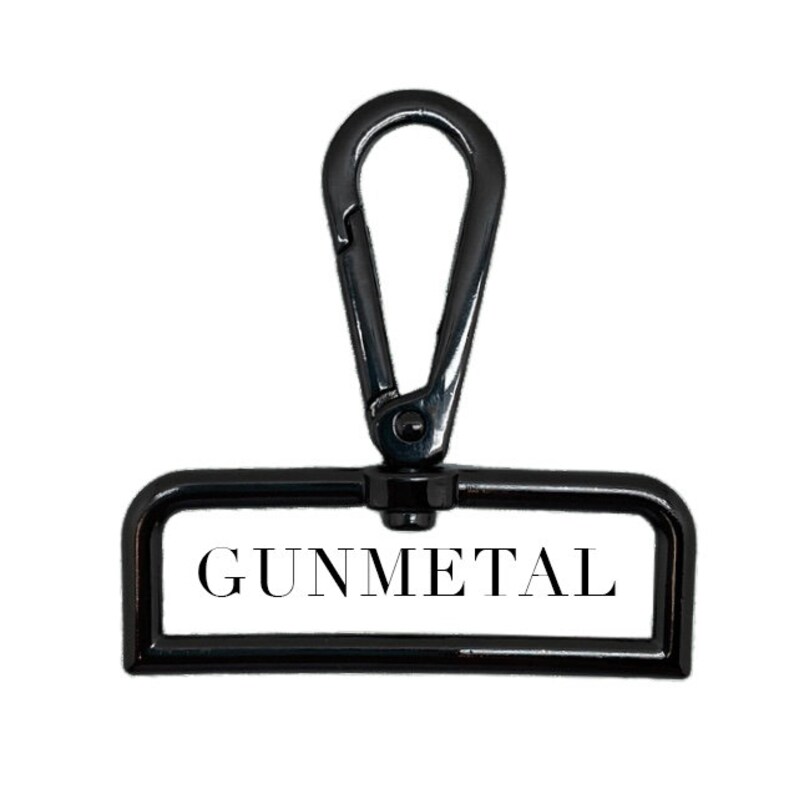 Puede incluir: Un gancho giratorio de metal negro con una etiqueta rectangular que dice "GUNMETAL".