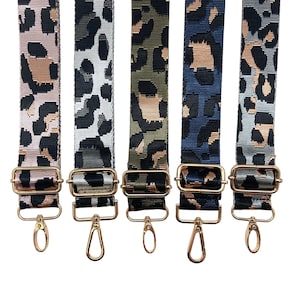 May include: Five different leopard print adjustable straps with gold hardware. The straps are pink, gray, green, blue, and light gray.