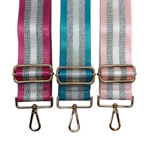 Peut inclure: Trois bandouli&egrave;res r&eacute;glables pour sacs &agrave; main, roses, turquoise et rose clair. Chaque sangle pr&eacute;sente des rayures argent&eacute;es et blanches, une quincaillerie m&eacute;tallique dor&eacute;e et un mousqueton pivotant. Pour sacs &agrave; main.