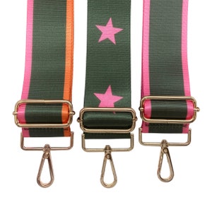May include: Three adjustable bag straps with gold-colored hardware. One strap is olive green with a pink star pattern. The other two straps are olive green with pink and orange stripes. All straps have gold-colored metal clasps.