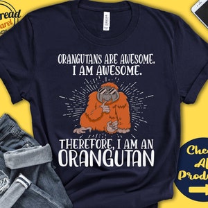 Puede incluir: Una camiseta azul marino con un gráfico de un orangután con gafas de sol y el texto "Los orangutanes son increíbles. Yo soy increíble. Por lo tanto, soy un orangután."