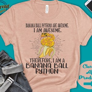 May include: A peach-colored t-shirt with the text "BANANA BALL PYTHONS ARE AWESOME. I AM AWESOME. THEREFORE, I AM A BANANA BALL PYTHON." A graphic of a yellow snake wearing sunglasses is inside a banana peel.