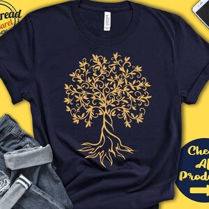 May include: A navy blue t-shirt with a gold tree design. The tree has intricate branches and roots. The shirt is a unisex style.