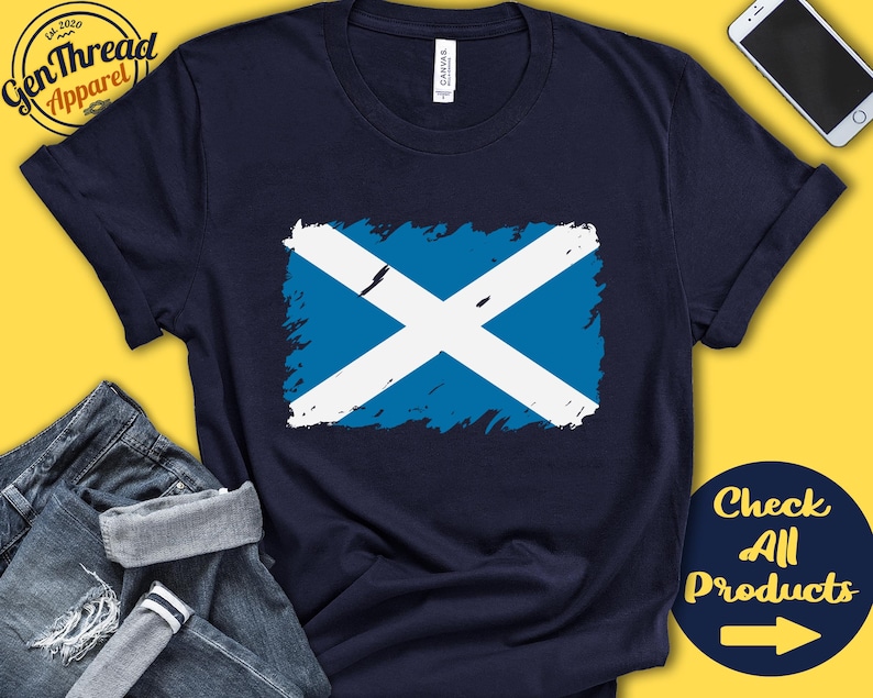 May include: A navy blue t-shirt with a distressed white and blue Scottish flag design. The text "Check All Products" with a right arrow is in the bottom right corner of the image.