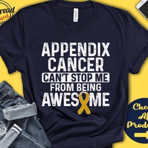 May include: A navy blue t-shirt with white text that reads "Appendix Cancer Can't Stop Me From Being Awesome". A gold ribbon is centered below the text.