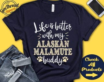 Pode incluir: Uma camiseta azul marinho com texto branco que diz "Life is better with my Alaskan Malamute buddy". O texto é cercado por pegadas de patas.