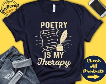 Puede incluir: Una camiseta azul marino con el texto "Poetry is my Therapy" en una fuente de estilo vintage. El diseño presenta un trozo de papel enrollado con una pluma y un tintero.