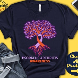 May include: Navy blue t-shirt with a purple and orange tree design. The tree is made up of many small ribbons. The text "Psoriatic Arthritis Awareness" is printed below the tree.