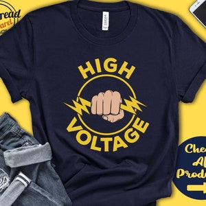 May include: A navy blue t-shirt with a yellow circle graphic that says "HIGH VOLTAGE" with a lightning bolt and a fist inside the circle.