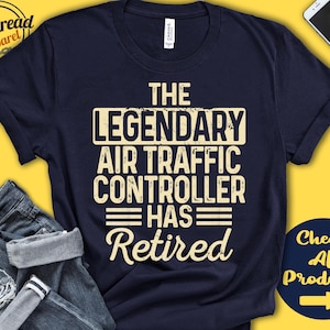 Op de afbeelding: Een marineblauw t-shirt met een gele afbeelding met de tekst "The Legendary Air Traffic Controller Has Retired".
