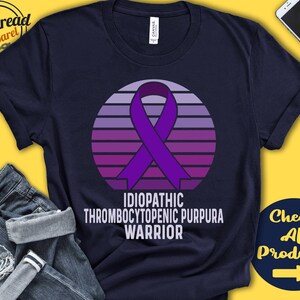 May include: A navy blue t-shirt with a purple ribbon and a sunset graphic. The text "Idiopathic Thrombocytopenic Purpura Warrior" is printed on the shirt.