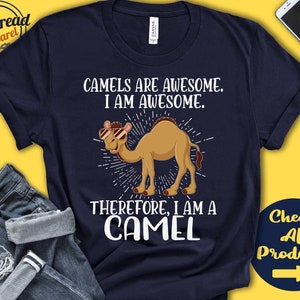 May include: Navy blue t-shirt with the text "CAMELS ARE AWESOME. I AM AWESOME. THEREFORE, I AM A CAMEL." A cartoon camel wearing sunglasses is in the center. The shirt also has the "Gen Thread Apparel" logo.
