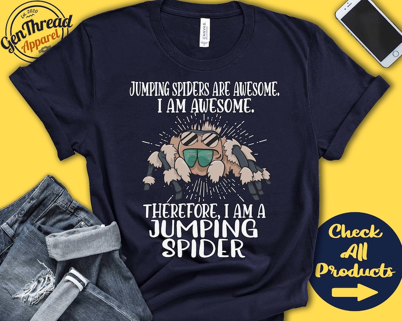 May include: A navy blue t-shirt with a white graphic of a jumping spider wearing sunglasses. The text "Jumping Spiders are Awesome. I am Awesome. Therefore, I am a Jumping Spider" is printed on the shirt.