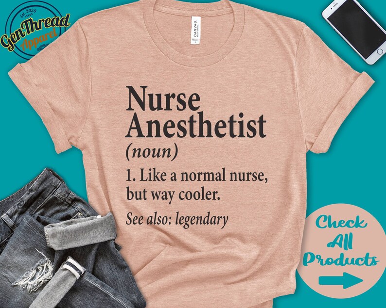 以下が含まれることがあります： 黒色の文字で「Nurse Anesthetist (noun) 1. Like a normal nurse, but way cooler. See also: legendary」と印刷された薄いピンク色のTシャツです。