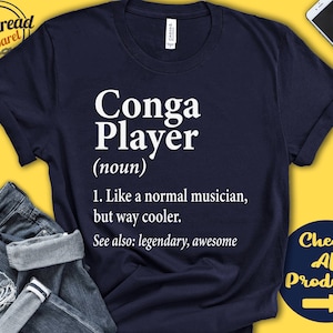 Op de afbeelding: Een marineblauw T-shirt met witte tekst die "Conga Player (zelfstandig naamwoord) 1. Net als een normale muzikant, maar veel cooler. Zie ook: legendarisch, geweldig" luidt.