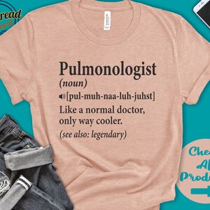 K&ouml;nnte beinhalten: Ein hellrosa T-Shirt mit dem Text "Pulmonologist (noun) [pul-muh-naa-luh-juhst] Like a normal doctor, only way cooler. (see also: legendary)"