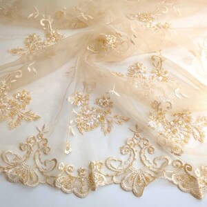 May include: Beige tulle fabric with gold embroidered floral designs and sequins.