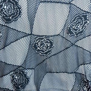 May include: A black fishnet fabric featuring a repeating geometric pattern of interconnected diamonds. Within the center of each diamond shape is a detailed, solid black rose motif integrated into the open-weave mesh construction.