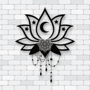 Puede incluir: Diseño de flor de loto negra con luna creciente y estrellas. La pieza decorativa presenta un mandala en el centro y cuentas y abalorios colgantes. El diseño está sobre una pared de ladrillos blancos.