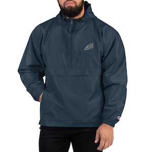 May include: A navy blue hooded windbreaker jacket with a zipper closure and a small embroidered shark design on the left chest. The jacket has a kangaroo pocket and elastic cuffs.