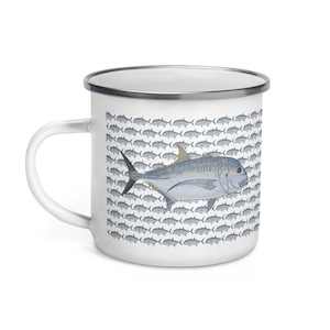 Könnte beinhalten: Weiße Email Tasse mit einer Illustration eines blauen und gelben Fisches. Der Fisch ist von einem Muster aus kleineren blauen Fischen umgeben.