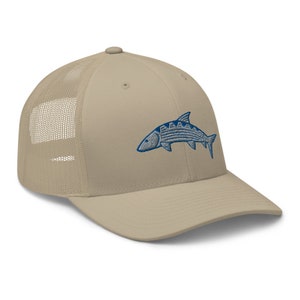 May include: A beige and brown mesh trucker hat with a blue embroidered fish design.