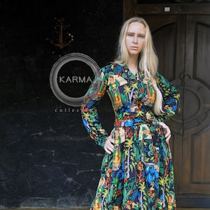 May include: A long-sleeved maxi dress with a black background and a colorful floral print. The dress has a button-up front and a belt at the waist. The print features a variety of flowers, leaves, and birds. The dress is made of a lightweight fabric and is perfect for warm weather.