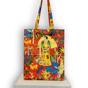 Könnte beinhalten: Eine rote Tragetasche mit einem bunten Druck, der eine Frau in einem gelben Kleid und einen floralen Hintergrund zeigt. Der Druck enthält den Text "Viva La Vida".