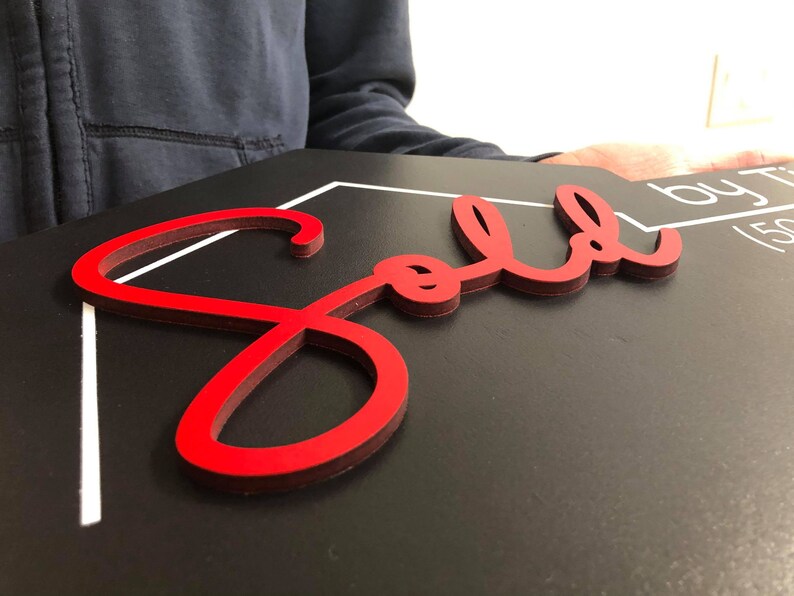 May include: A red "Sold" sign with a white border on a black background.
