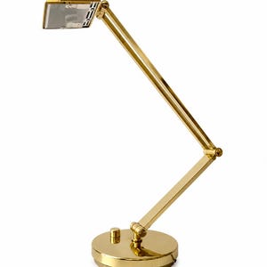 May include: A gold-colored desk lamp with an adjustable arm and a round base. The lamp has a rectangular light fixture and a small on/off switch on the base. The design is sleek and modern, suitable for a home office or study.