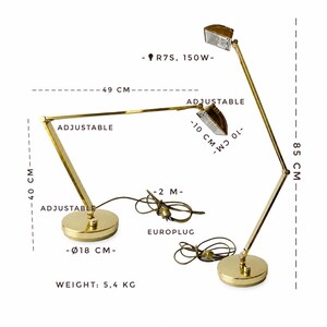 May include: A gold-toned adjustable desk lamp with a round base, measuring 18 cm in diameter. The lamp extends to 49 cm and is 85 cm tall. It features a 150W bulb and a 2-meter cord. The lamp weighs 5.4 kg.