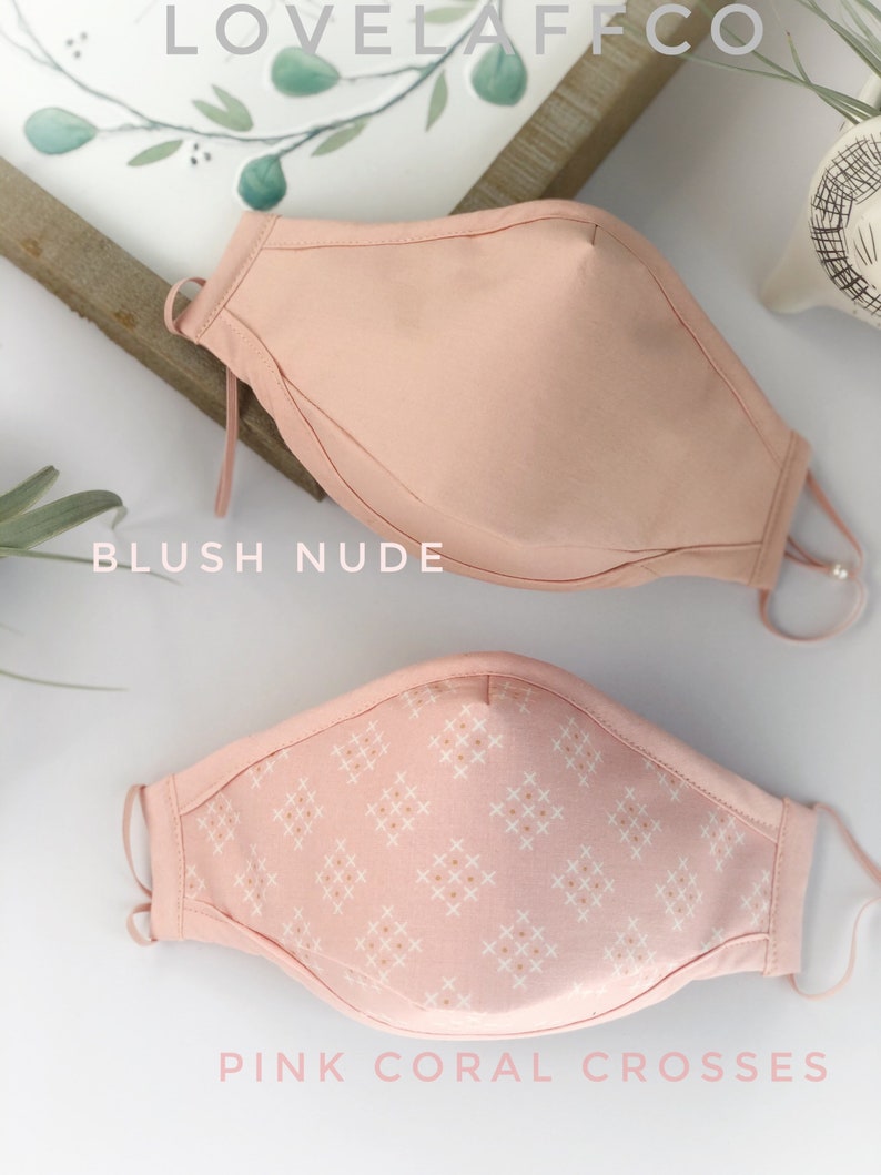 Op de afbeelding: Twee gezichtsmaskers. Het bovenste masker is blush nude, en het onderste masker is roze koraal kruisen. Beide maskers hebben verstelbare oorlussen. De merknaam "LOVELAFFCO" staat bovenaan de afbeelding.