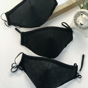 May include: Three black face masks with different patterns. The masks have elastic ear loops and a wire nose piece.