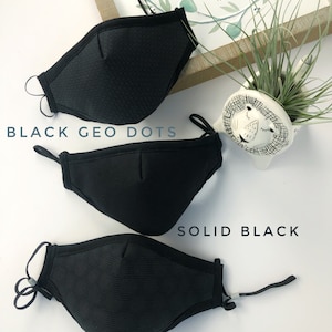 May include: Three black face masks with different patterns. The top mask has a black geometric dot pattern, the middle mask is solid black, and the bottom mask has a black circle pattern. The masks are all made of a soft, breathable fabric.
