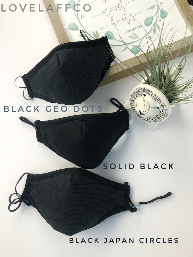 May include: Three black face masks with different patterns. The top mask has a black geometric dot pattern, the middle mask is solid black, and the bottom mask has a black circle pattern. The masks are all made of a soft, breathable fabric.