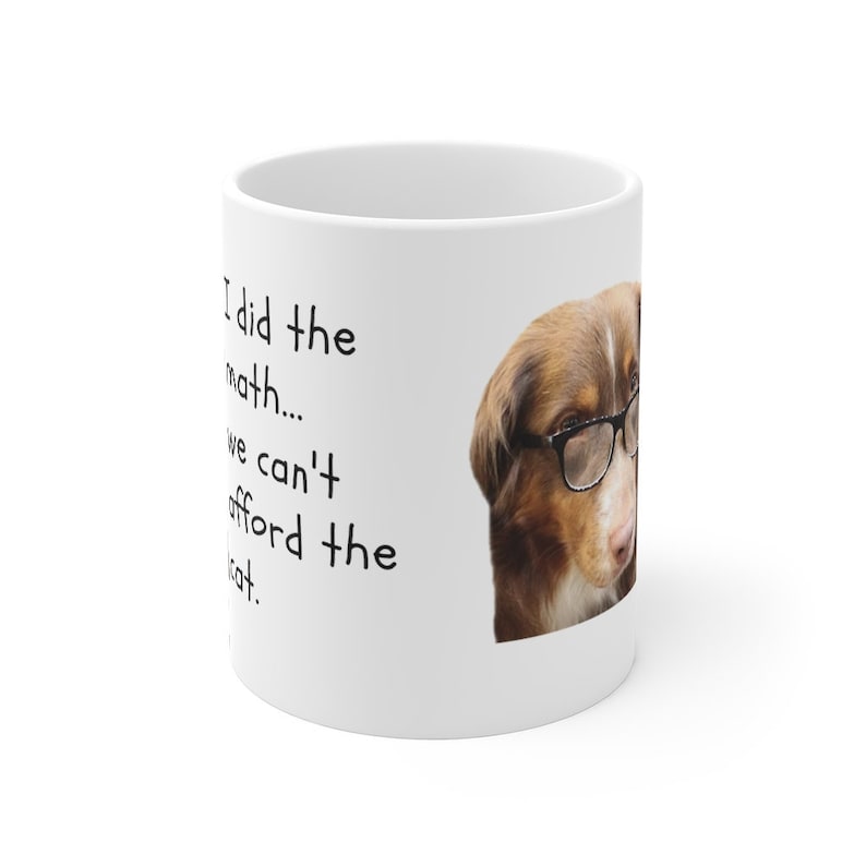 Puede incluir: Taza de cer&aacute;mica blanca con un perro marr&oacute;n y blanco que lleva gafas. La taza tiene el texto "Hice las cuentas... no podemos permitirnos el gato."