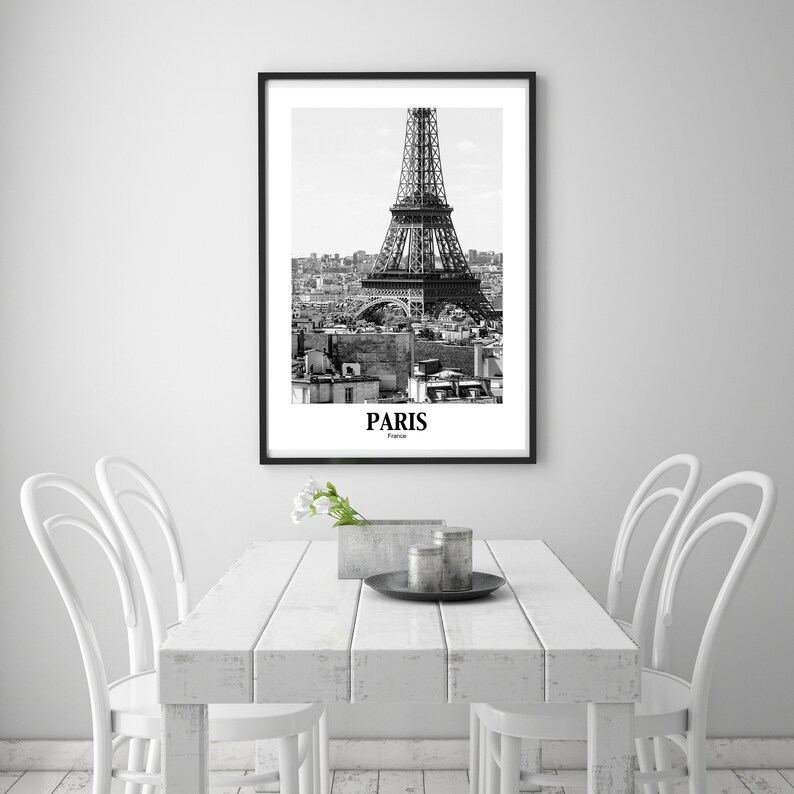 May include: Black and white framed print of the Eiffel Tower in Paris, France. The image features the iconic landmark against a cityscape, with the word "PARIS" and "France" printed below the image.