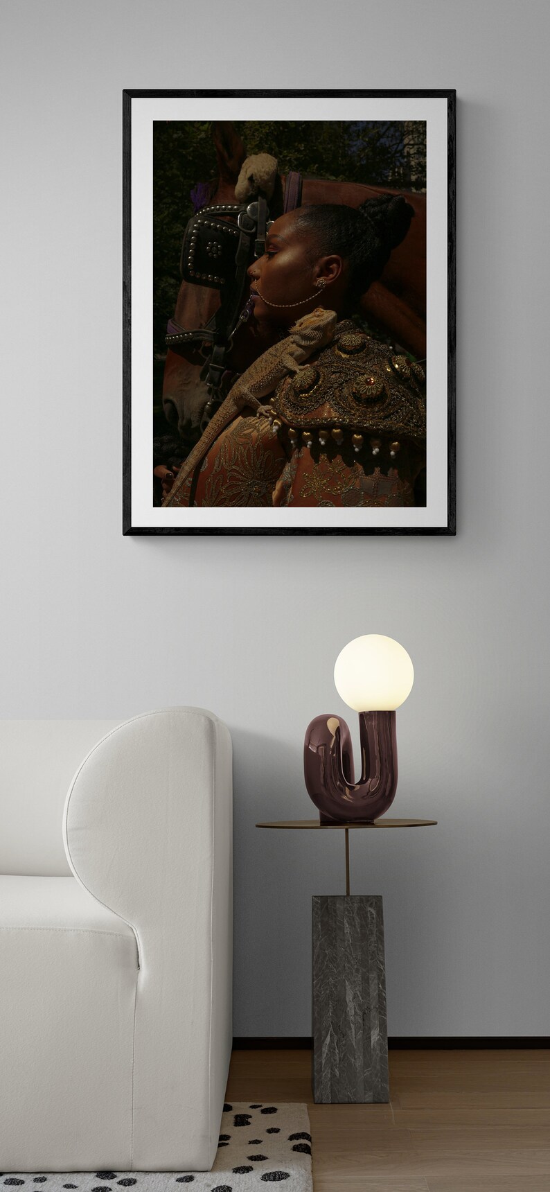 Puede incluir: Una fotograf&iacute;a enmarcada de una persona con un lagarto en el hombro, de pie junto a un caballo. La persona lleva una chaqueta con estampado dorado y marr&oacute;n. La fotograf&iacute;a est&aacute; colgada en una pared blanca.