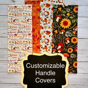May include: A collection of customizable handle covers with autumn-themed patterns. Designs include fall leaves, pumpkins, foxes, sunflowers, and mushrooms. The covers are displayed against a light wood background. Text on a chalkboard reads "Customizable Handle Covers."