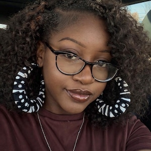 May include: A set of three ceramic mugs with a speckled, matte finish. Each mug features a different color: light blue, cream, and gray. The mugs have a simple, modern design with a rounded shape and a comfortable handle.