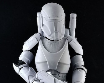 Può includere: Una action figure di plastica bianca di un clone trooper di Star Wars. La figura tiene un fucile blaster e indossa un elmetto con una visiera. La figura è in piedi su una base nera con un logo che dice "One Sixth Clones".