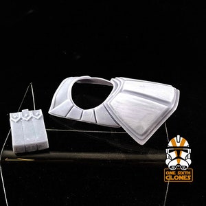 Puede incluir: Un modelo impreso en 3D de pl&aacute;stico blanco de una armadura de soldado clon de Star Wars, que incluye la placa del pecho y una pieza separada para la espalda. El modelo est&aacute; sobre una superficie negra.