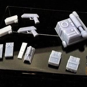 May include: A set of 3D printed plastic miniatures for a tabletop game or role-playing game. The set includes a variety of weapons, equipment, and accessories, including a blaster pistol, a backpack, and a utility belt.