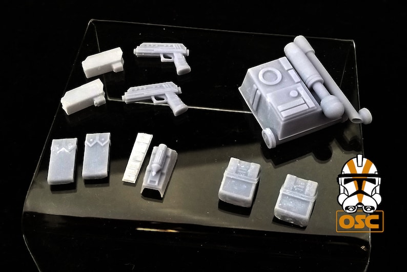 May include: A set of 3D printed plastic miniatures for a tabletop game or role-playing game. The set includes a variety of weapons, equipment, and accessories, including a blaster pistol, a backpack, and a utility belt.