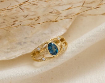 May include: A gold ring with a blue gemstone and small white gemstones set in a delicate filigree design.