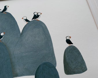 May include: A framed illustration of a group of puffins perched on gray rocks against a white background.
