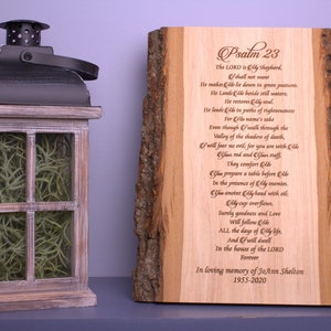 May include: A wooden plaque with a bark edge, featuring an engraved version of Psalm 23. The plaque is a memorial for JoAnn Shelton, 1955-2020.